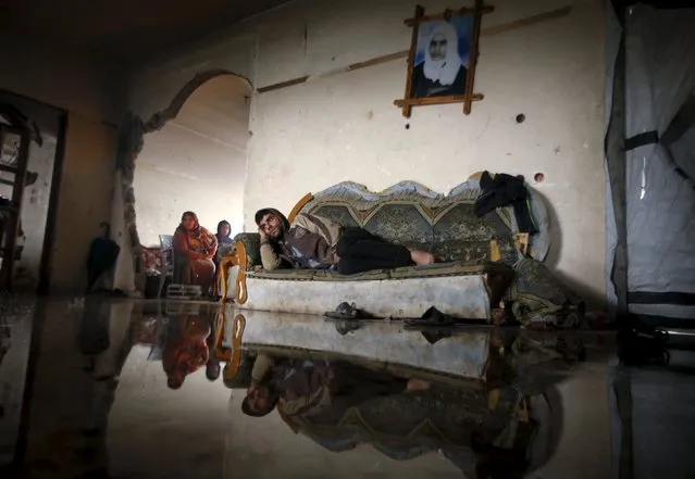 A Palestinian man lies on a couch in his flooded house that was damaged during the 2014 war, on a rainy day in Beit Hanoun in the northern Gaza Strip, January 24, 2016. (Photo by Mohammed Salem/Reuters)