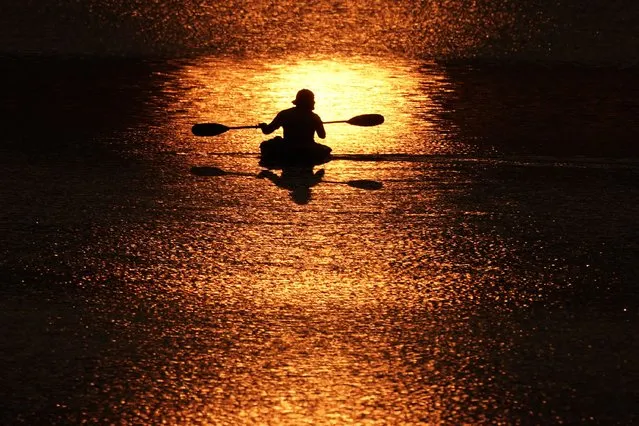 A boater paddles across a lake at sunset, Wednesday, October 4, 2023, in Shawnee, Kan. (Photo by Charlie Riedel)/AP Photo