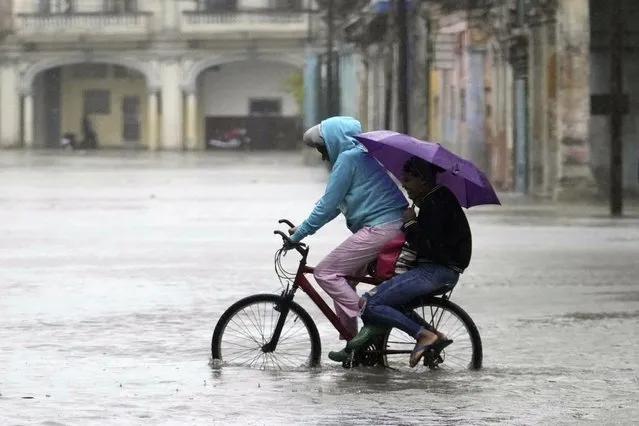 Commuters cycle through a street flooded by rain brought by Hurricane Idalia in Havana, Cuba, early Tuesday, August 29, 2023. (Photo by Ramon Espinosa/AP Photo)