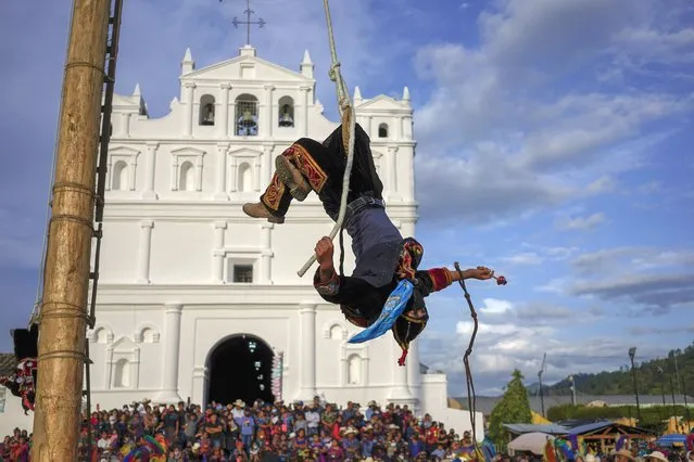 A dancer dressed as a monkey performs “Danza del Palo Volador”, a ritual in honor of his patron saint Santiago Apostle, in Cubulco, Guatemala, Thursday, July 21, 2022. Ahead of his feast day on July 25 worshipers take part in ancient religious ceremonies and accompany processions since a few weeks before. (Photo by Moises Castillo/AP Photo)
