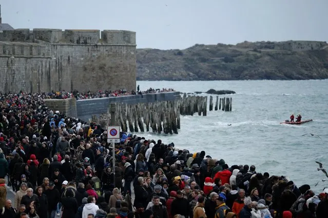 People gather on the waterfront to watch the incoming high tide in Saint Malo, western France, March 21, 2015. (Photo by Stephane Mahe/Reuters)