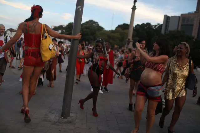 Participants perform on the street before a fashion show organized by Daspu, a fashion house founded and run by prostitutes, during the Women of the World (WOW) festival, in Rio de Janeiro, Brazil November 18, 2018. (Photo by Pilar Olivares/Reuters)