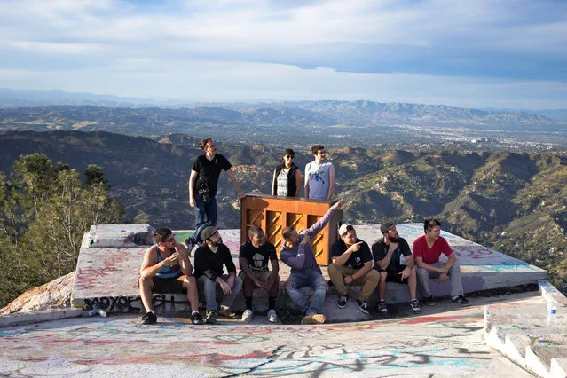 In this March, 2015 photo, members of a music video crew pose at Topanga Lookout in the Santa Monica Mountains with an upright piano they hauled up there in Calabasas, Calif. (Photo by Michael Flotron/AP Photo)