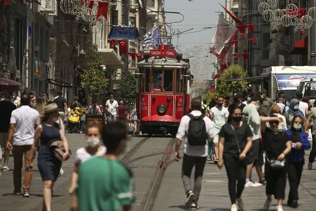 People walk on Istiklal Street, the main shopping street in Istanbul, Thursday, July 1, 2021. (Photo by Emrah Gurel/AP Photo)