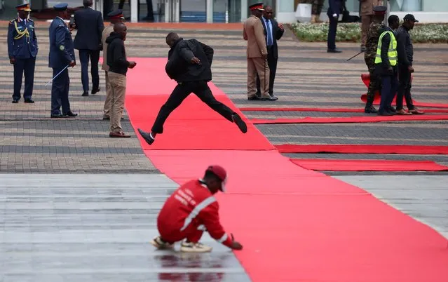 People roll out the red carpet ahead of the arrival of Britain's King Charles and Queen Camilla at the Tomb of the Unknown Warrior on their state visit to Kenya at the Uhuru Gardens in Nairobi, Kenya on October 31, 2023. (Photo by Phil Noble/Reuters)
