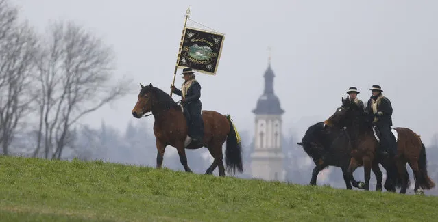 Local residents dressed in traditional  Bavarian clothes  ride during  the traditional Georgi (St. George)  horse riding procession on Easter Monday in Traunstein, southern Germany, Monday, April 6, 2015. (Photo by Matthias Schrader/AP Photo)