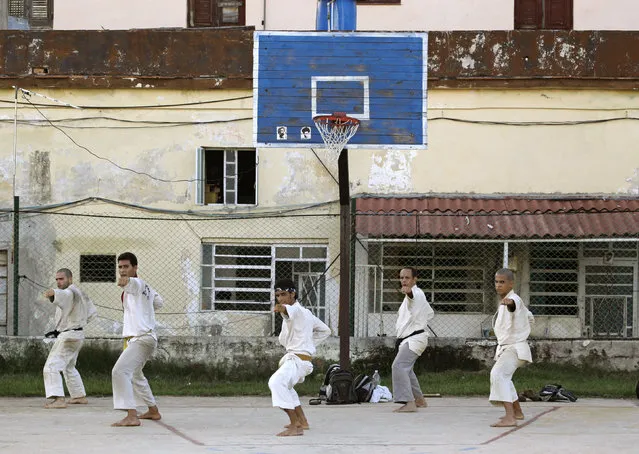 Men practice martial arts on a basketball court in Havana, Cuba, August 2010. (Photo by Desmond Boylan/Reuters)