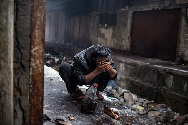 A migrant washes his face in a makeshift shelter at an abandoned warehouse in Belgrade on January 10, 2017, as temperatures dropped to –15 degrees Celsius over night. According to the latest figures, around 7000 migrants are stranded in Serbia. (Photo by Andrej Isakovic/AFP Photo)