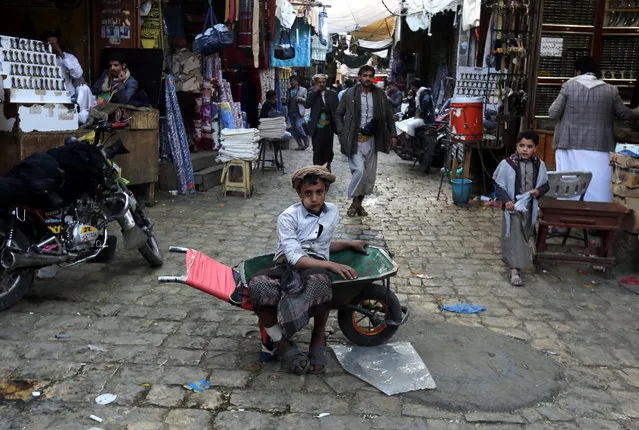 A Yemeni boy (C) working in ferrying goods waits to be hired at a market in the old quarter of Sana'a, Yemen, 25 December 2018. Yemen has been engulfed in a four-year conflict since the Saudi-led coalition launched its military campaign to roll back the Houthi rebels and reinstate the country’s exiled government in the capital Sana'a. (Photo by Yahya Arhab/EPA/EFE)