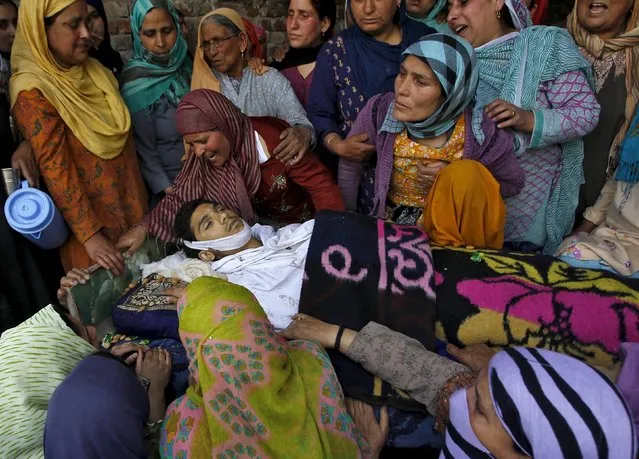 Relatives mourn next to the body of a Kashmiri youth, who died in a clash between Kashmiri protesters and police during a daylong protest strike in Narbal, north of Srinagar April 18, 2015. (Photo by Danish Ismail/Reuters)