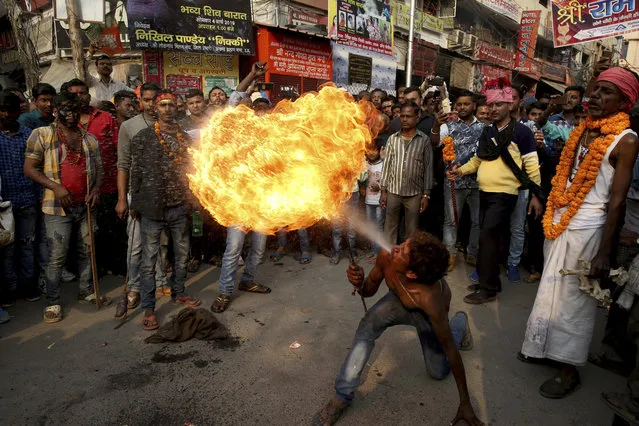 A devotee performs fire breathing stunts during a procession to mark Mahashivratri festival in Prayagraj, Uttar Pradesh state, India, Monday, March 4, 2019. “Shivaratri”, or the night of Shiva, is dedicated to the worship of Lord Shiva, the Hindu god of death and destruction. (Photo by Rajesh Kumar Singh/AP Photo)