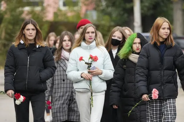 Students walk to lay flowers outside the Perm State University following a campus shooting in Perm, about 1,100 kilometers (700 miles) east of Moscow, Russia, Tuesday, September 21, 2021. (Photo by Dmitri Lovetsky/AP Photo)