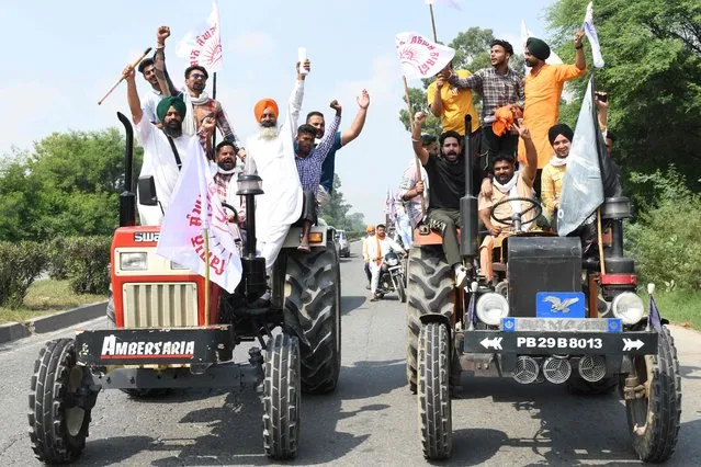 Farmers shout slogans from their tractors during a nationwide strike against the central government's agricultural reforms on the outskirts of Amritsar on September 27, 2021 (Photo by Narinder Nanu/AFP Photo)