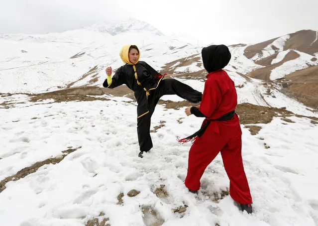 Sima Azimi (L), 20, a trainer at the Shaolin Wushu club, and Shakila Muradi, 18, show their Wushu skills to other students on a hilltop in Kabul, Afghanistan January 29, 2017. (Photo by Mohammad Ismail/Reuters)