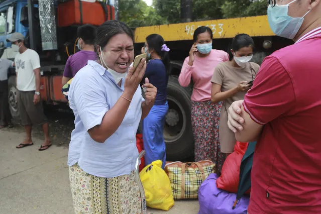 A woman talks to her family members on a phone after she was released from the Insein Prison Tuesday, October 19, 2021, in Yangon, Myanmar. (Photo by AP Photo/Stringer)