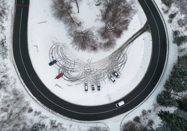 Cars are parked in a snowy corner of a road near Schmitten, Hessen, Germany on Tuesday, January 16, 2024. (Photo by Boris Roessler/AP Photo)