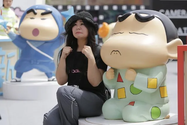 A visitor poses for a photo with a Crayon Shin-chan model during an exhibition at Joy City in Beijing May 5, 2015. The exhibition, which showcased fifty models of the Japanese cartoon character in different poses and expressions, will run from April 18 to June 22. (Photo by Jason Lee/Reuters)