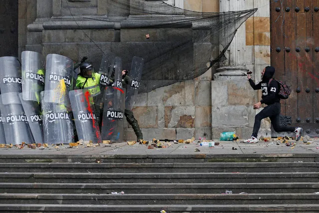A demonstrator throws a stone to riot police during a protest for a national strike, in Bogota, Colombia on April 25, 2019. (Photo by Luisa Gonzalez/Reuters)