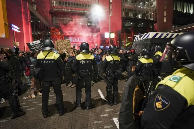 Riot police officers face protesters as they gather in the Hague, on November 12, 2021, during a press conference of Dutch Prime Minister held to announce new Covid-19 restrictions. Dutch Prime Minister Mark Rutte announced three weeks of tough anti-Covid measures on hospitality, shops and sport to curb a record rise in infections. (Photo by Jeroen Jumelet/ANP via AFP Photo)