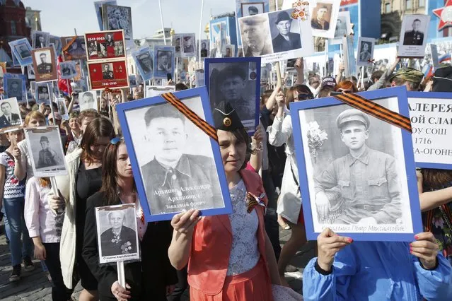 People hold pictures of World War Two soldiers as they take part in the Immortal Regiment march during the Victory Day celebrations at Red Square in Moscow, Russia, May 9, 2015. (Photo by Maxim Shemetov/Reuters)