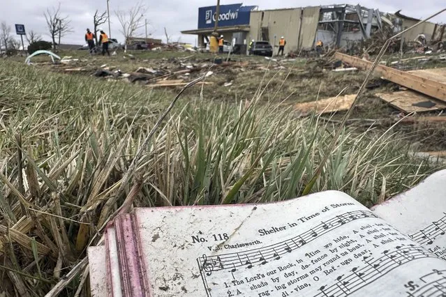 A hymnal book from a destroyed church across the street is seen among the debris strewn in Winchester, Ind., on Friday, March 15, 2024, after storms ripped through the area Thursday night. (Photo by Isabella Volmert/AP Photo)