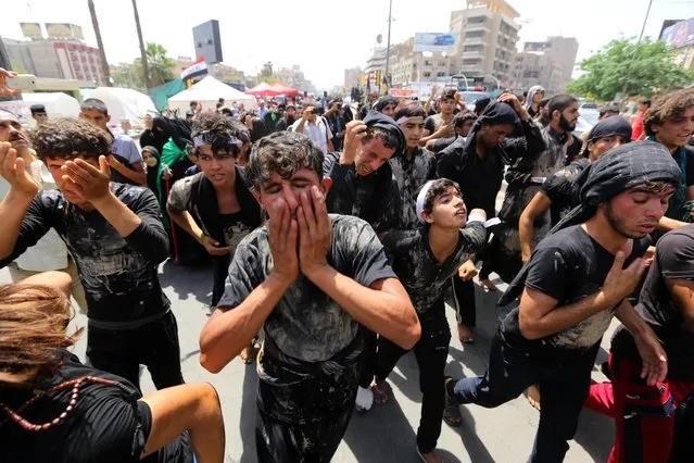 Shiite pilgrims beat themselves and cover themselves with mud as they march toward the Imam Mousa al-Kazim shrine to commemorate the anniversary of the imam's death in Baghdad, Iraq, Monday, May 11, 2015. The anniversary of the 8th-century imam's death draws tens of thousands of Shiites from all walks to converge on his golden-domed shrine in northern Baghdad. (Photo by Hadi Mizban/AP Photo)