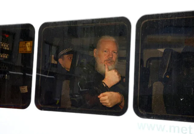 WikiLeaks founder Julian Assange in a police van after being arrested by British police outside the Ecuadorian embassy in London on 11 April 2019. (Photo by Henry Nicholls/Reuters)
