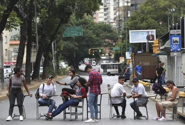 Instituto de Nuevas Profesiones' student block an avenue to protest a tuition increase in Caracas, Venezuela, Wednesday, May 8, 2019. Venezuela has been in sharp decline for years, suffering from hyperinflation and shortages of food and medicine. (Photo by Martin Mejia/AP Photo)