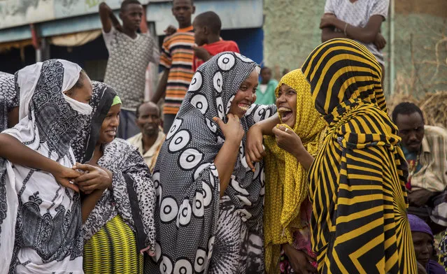 Ethiopian women chat after receiving aid distributed under a European Union funded project, in the Shinile Zone of Ethiopia on April 8, 2016, near the border with Somalia. (Photo by Mulugeta Ayene/AP Photo)