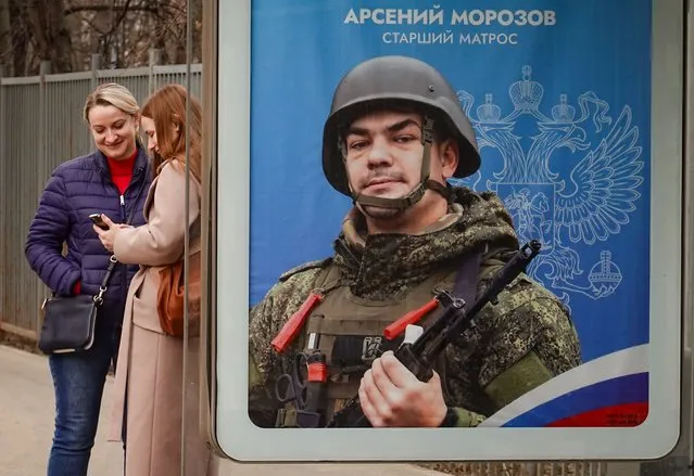 Women stand at a bus stop next to an advertisement for military conscription showing a Russian soldier, in Moscow, Russia, 08 April 2024. According to Russian Defence Minister Sergei Shoigu, almost 540 thousand people entered military service under contract in the Russian Armed Forces in 2023, and about 50 thousand since the beginning of 2024. (Photo by Yuri Kochetkov/EPA/EFE)