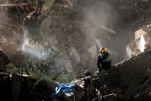 A rescue worker searches at the site after a three-storey residential building collapsed in Shanghai, China, April 11, 2016. (Photo by Aly Song/Reuters)