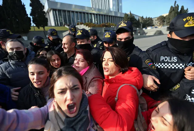 Police officers push back protesters during a rally of journalists against a new media bill, in front of the Parliament building in Baku, Azerbaijan on December 28, 2021. (Photo by Aziz Karimov/Reuters)