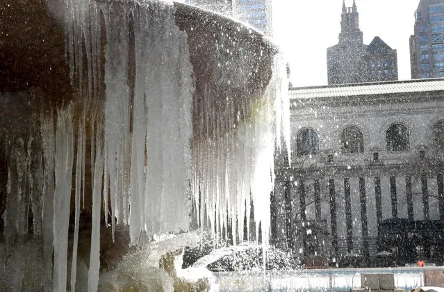 The Josephine Shaw Lowell Memorial Fountain in Bryant Park is covered in ice on March 13, 2017 as the weather continues to be below freezing. The northeastern United States braced Monday for what meteorologists predict could be the worst winter storm of the season, with blizzards feared to dump knee- high snow on New York. (Photo by Timothy A. Clary/AFP Photo)