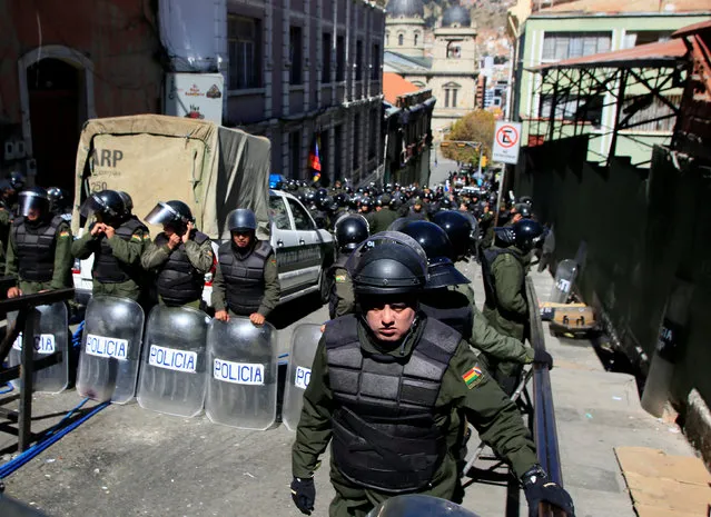 Riot police guard one of the entrances to Murillo square, during a protest by people with physical disabilities demanding the government to increase their monthly disability subsidy, in La Paz, Bolivia, April 29, 2016. (Photo by David Mercado/Reuters)