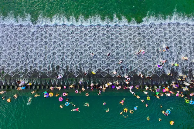 People cool off at the Longquan Dam near Ningbo, China in high temperatures on July 23, 2019. (Photo by Costfoto/Barcroft Media)