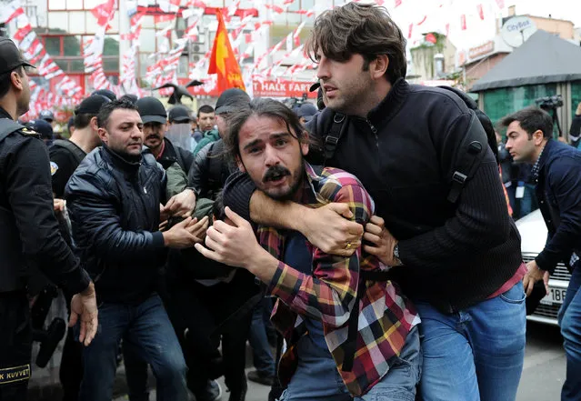 A plainclothes police officer detains a protester as he and others attempted to defy a ban and march on Taksim Square to celebrate May Day, in Besiktas neighbourhood of Istanbul, Turkey, May 1, 2016. (Photo by Yagiz Karahan/Reuters)