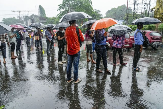 Stranded passengers await transport in Kolkata, India, as rain continues after cyclone Remal made a landfall near Bangladesh-India border, Monday, May 27, 2024. (Photo by Bikas Das/AP Photo)