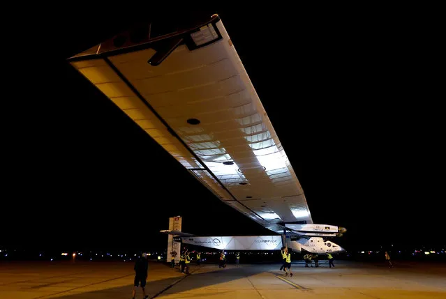 Members of the ground crew are lifted off the ground as the wind begins to move the Swiss-made Solar Impulse 2 plane, Monday, May 2, 2016, in Goodyear, Ariz. The plane left early Monday from California for a 16-hour trip to Phoenix to resume its journey around the world using only energy from the sun. (Photo by Matt York/AP Photo)