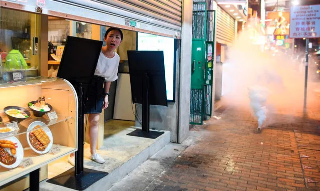 A woman reacts as Police personnel fire tear-gas shells to disperse Pro-Democracy protestors in the Sham Shui Po Area of Hong Kong on August 14, 2019. More than 10 weeks of sometimes-violent demonstrations have wracked the semi-autonomous city, with millions taking to the streets to demand democratic reforms and police accountability. (Photo by Manan Vatsyayana/AFP Photo)
