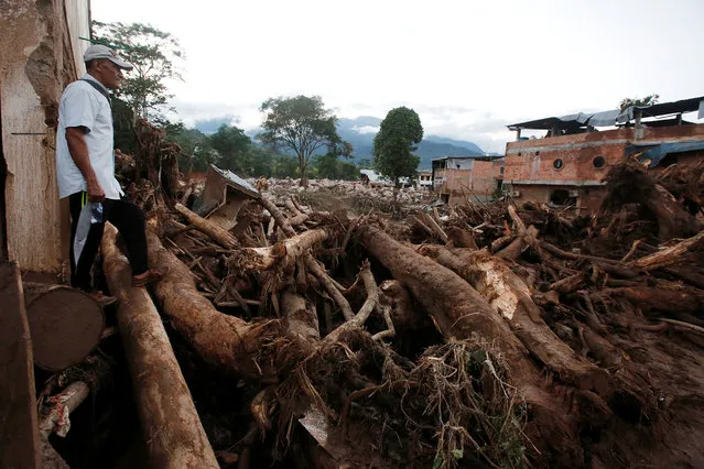 A man looks at a destroyed area after heavy rains caused several rivers to overflow, pushing sediment and rocks into buildings and roads in Mocoa, Colombia April 1, 2017. (Photo by Jaime Saldarriaga/Reuters)