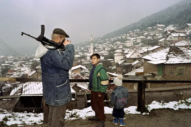 A Bosnian fighter views the Old City section of Sarajevo as it is covered with this winter' s first snow 19 November, 1992. The snow fall coincides with shortages of gas, coal, electricity and other fuels because of the seven- month- old ethnic war in the former Yugoslovia Republic of Bosnia- Herzegovina. (Photo by Patrick Baz/AFP Photo)