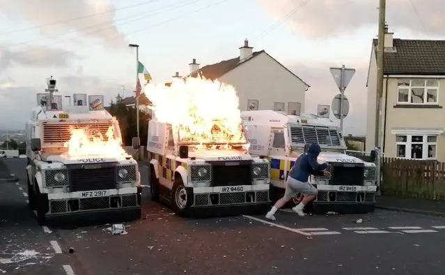 A person runs after throwing a petrol bomb at PSNI vehicles, after a security alert was upturned due to a suspicious package found in Creggan Heights, Derry, Northern Ireland on September 9, 2019 in this still image obtained from a social media video. (Photo by Derry Footage via Reuters)