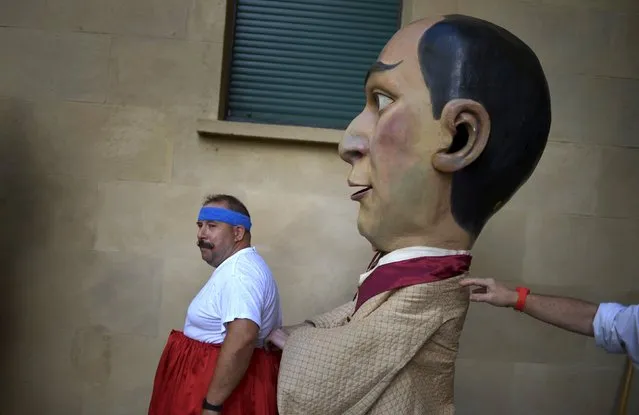 Kilikis help each other dress during San Fermin festival's “Comparsa de gigantes y cabezudos” (Parade of the Giants and Big Heads) in Pamplona, northern Spain, July 8, 2015. (Photo by Vincent West/Reuters)