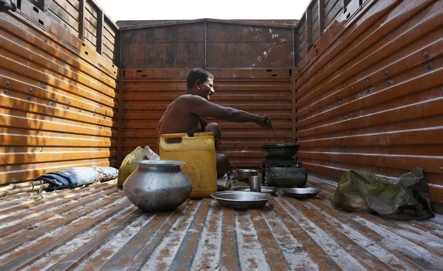 A driver cooks his meals in the back of a supply truck at a market in Kolkata, India, May 5, 2016. (Photo by Rupak De Chowdhuri/Reuters)