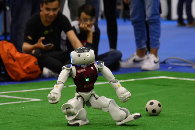 Visitors watch a tournament of robot footballers at the 7th edition of the Maker Faire 2019, the greatest European event on innovation, on October 18, 2019 in Rome. “RoboCup”, a triangular tournament of robot footballers involving the teams of Rome's Sapienza University and two other universities from Switzerland and Germany as protagonists. (Photo by Andreas Solaro/AFP Photo)