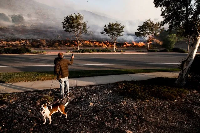 A resident watches from the side of the road the Easy Fire spreading in Simi Valley, North of Los Angeles, Calif., on October 30, 2019. (Photo by Etienne Laurent/EPA/EFE/Rex Features/Shutterstock)