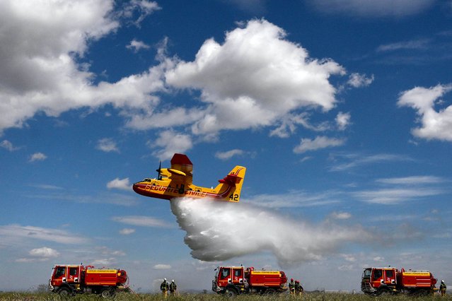 A Canadair (water bomber) sprays water during a demonstration of civil security forest firefighting equipment at their base the airport of Nimes-Garons, southern France, on April 25, 2023. (Photo by Christophe Simon/AFP Photo)