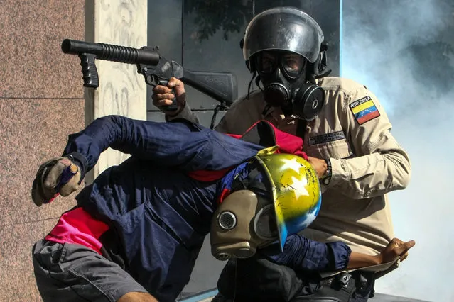 Protesters clash with members of the Bolivarian National Police (PNB) during an anti-government march in Caracas, Venezuela, 20 May 2017. Venezuelan security forces used tear gas to disperse demonstrators who were trying to reach the headquarters of the Interior Ministry, in the city center. Anti-government demonstrators have led protests against Venezuelan President Nicolas Maduro for 50 days paralyzing the divided country. At least 47 people died in violence related to the protests, media reported. (Photo by Cristian Hernandez/EPA)