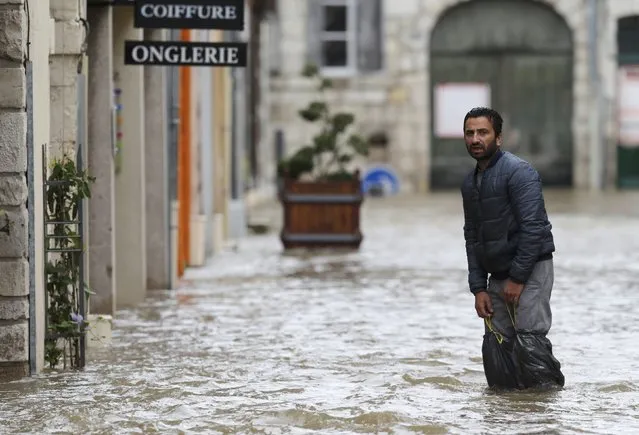 A man walks in a flooded street in Montargis in the Loiret, following heavy rain in France June 1, 2016. (Photo by Christian Hartmann/Reuters)