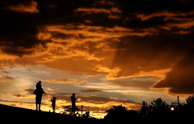 The sky turns orange as the clouds part from a storm above Sparks Marina Park as the sun sets, Friday, July 10, 2015, in Sparks, Nev. (Photo by Larry Steagall/Kitsap Sun via AP Photo)